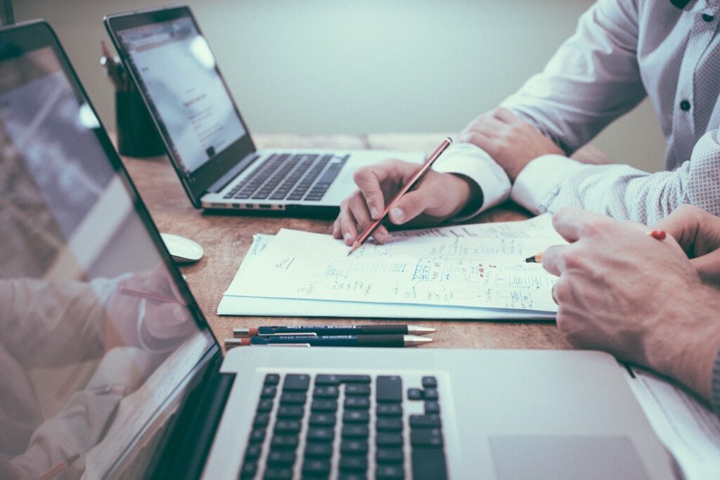 Due persone lavorano al computer con documenti.